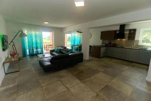 un soggiorno con un divano nero e una cucina di Villa Nerium a Malinska