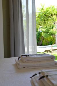ein Haufen Handtücher auf einem Tisch mit einem Fenster in der Unterkunft Casa MaLu Boutique Apartments - No 2 in Gouvia