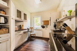 a kitchen with white cabinets and a table at Ferienwohnung HarzReise in Braunlage +30 photos