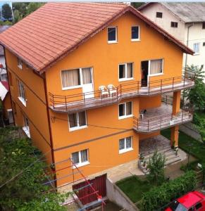 une maison orange avec des balcons sur son côté dans l'établissement Vila Mirela, à Eforie Nord