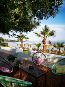 Hotel Akti Kavala في بالايون تسيفليكيون: فناء مع كراسي وطاولة مطلة على المحيط