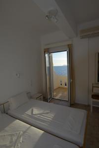 a bedroom with a bed and a large window at Nefeli in Kalamaki Heraklion