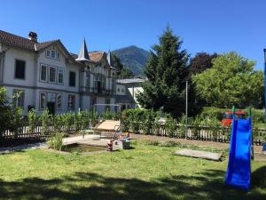 a yard with a house and a blue slide at Interlaken Marco Hostel in Interlaken