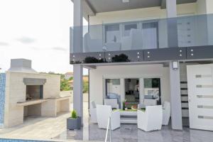 a modern house with white furniture and a balcony at LUXURY VILLA BEGANOVIC-VRH in Vrh