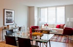 a living room with a glass table and red chairs at Furnished Quarters at 15/25 Bank Street in White Plains +7 photos