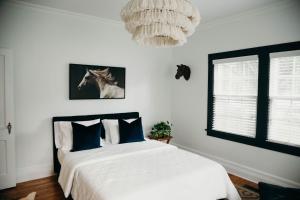 a bedroom with a bed and a chandelier at The Paddock Luxury Vacation Home in Hot Springs