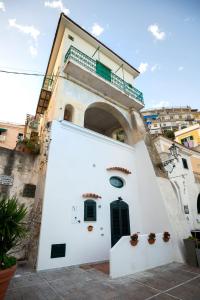 - un bâtiment blanc avec une porte verte et une arche dans l'établissement MARINELLA CASA VACANZE, à Cetara
