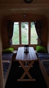 a table in a room with two beds and a window at Gaišie in Jūrmalciems