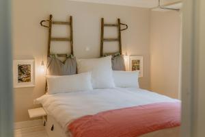 a bedroom with a large white bed with twoadders on the wall at Lieblings Platz hytte in Kirburg