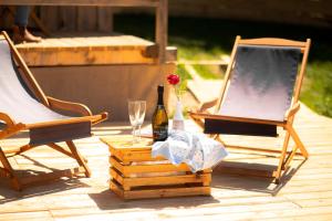 a bottle of wine and two chairs on a patio at Alp Glamping Village in Radovljica