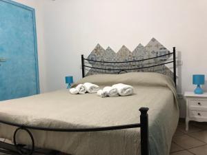 um quarto com uma cama com toalhas em Le terre cotte em Decimomannu