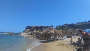 a group of people on a beach with umbrellas at Detached House in Sykia in Sikia