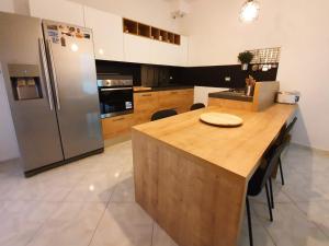 a kitchen with a refrigerator and a table with chairs at B&B TERRA DI MITI in Acireale