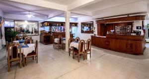 un restaurante con mesas y sillas y un bar en Hotel Termasol en Termas de Río Hondo