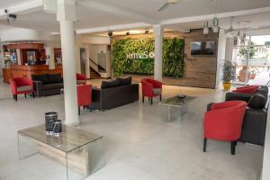 a lobby with couches and red chairs and a tv at Hotel Termasol in Termas de Río Hondo +25 photos