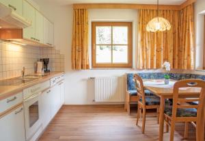a kitchen with a table and chairs and a window at Haus Lärchenwald in Niederthai