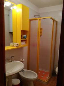 uma casa de banho com um chuveiro, um lavatório e um WC. em Bilocale con box - Condominio Cardinello Rosa em Madesimo