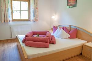 a bedroom with a bed with pink and purple pillows at Haus Lärchenwald in Niederthai