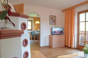 a living room with a television and a dining room at Haus Lärchenwald in Niederthai