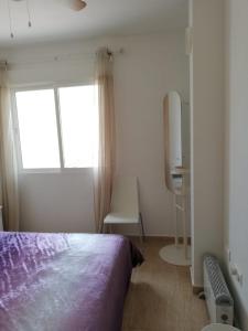 sypialnia z łóżkiem, oknem i krzesłem w obiekcie Spacious modern apartment in Los Alcazares very close to beach w mieście Los Alcázares