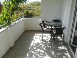 a balcony with chairs and a table and a window at Apartments Antica in Šimuni