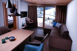 sala de estar con mesa y sofá en Alpinlodge Ladis, en Ladis