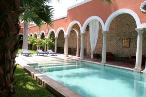 dziedziniec z basenem i budynkiem w obiekcie Hotel Hacienda Mérida w mieście Mérida