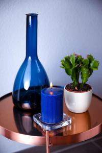 eine blaue Vase und eine Kerze auf dem Tisch in der Unterkunft Alpinlodge Ladis in Ladis