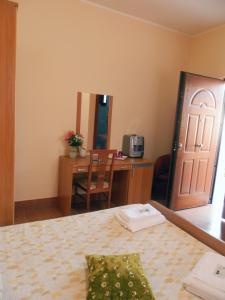 1 dormitorio con cama, escritorio y puerta en Luana Inn Holiday, en Fiumicino