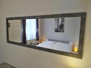 a mirror on the wall of a bedroom with a bed at Lentilka in Horní Planá