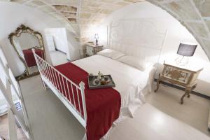una camera con un letto bianco e una coperta rossa di Kate a Leverano