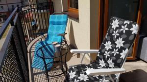 a couple of chairs sitting on a balcony at APARTAMENT QUEEN KARWIA in Karwia