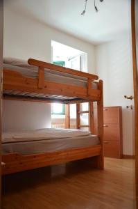 1 dormitorio con 2 literas y ventana en Appartamento Bruna, en Dimaro