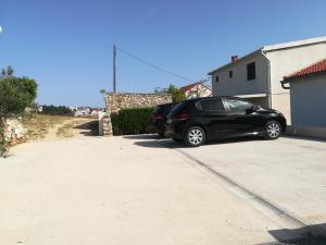 a black car parked in a parking lot at Apartments Antica in Šimuni