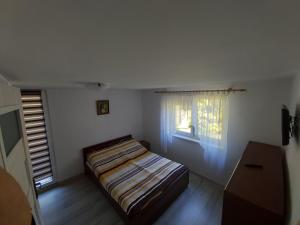 - une petite chambre avec un lit et une fenêtre dans l'établissement Agroturystyka Stajnia Horyzont, à Jarosławiec