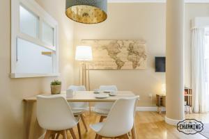 a dining room with a table and white chairs at Charming Fuencarral III - Estancias Temporales in Madrid