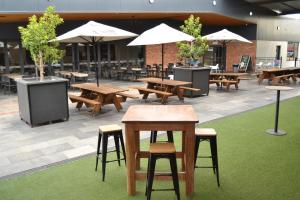 达博Garden Hotel的配有桌椅和遮阳伞的露台