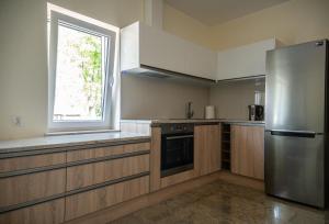 a kitchen with a stainless steel refrigerator and a window at Apartamenty Marynarki Wojennej, Dziwnów in Dziwnów