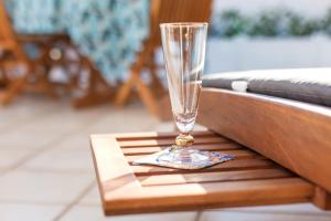 a glass sitting on top of a wooden table at Near The Port Apartment in Cala Gonone