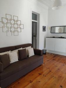 - un salon avec un canapé brun et du parquet dans l'établissement Paço da Rainha Apartment, à Lisbonne
