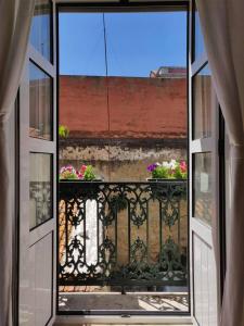 - une vue depuis une fenêtre ouverte sur un balcon fleuri dans l'établissement Paço da Rainha Apartment, à Lisbonne