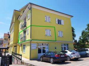 żółty budynek z samochodami zaparkowanymi przed nim w obiekcie Apartment Matika, terrace apartment 10 minutes walk from center w Rovinj