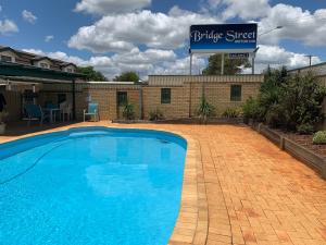 
a blue and white swimming pool in front of a building at Bridge Street Motor Inn in Toowoomba
