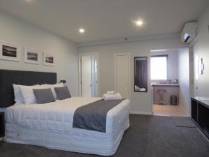ein Schlafzimmer mit einem großen weißen Bett in einem Zimmer in der Unterkunft The Studio Akaroa in Akaroa