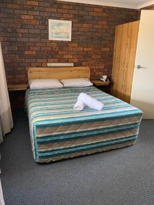 
a bed in a room with a blue wall at Bridge Street Motor Inn in Toowoomba
