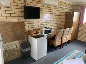 
a kitchen with a table and chairs and a microwave at Bridge Street Motor Inn in Toowoomba
