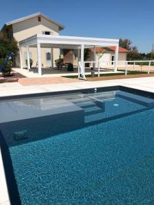 a large swimming pool in front of a house at Ca' Mira - Room&Breakfast in Savio di Ravenna