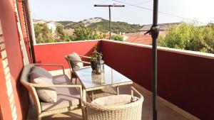 - un balcon avec une table, deux chaises et un parasol dans l'établissement Apartment Matija, à Čunski
