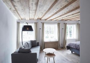 a living room with a couch and a bed and windows at Faktorei in Innsbruck