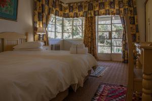 a bedroom with a large white bed and a window at Valley Of The Rainbow Estate in Dullstroom